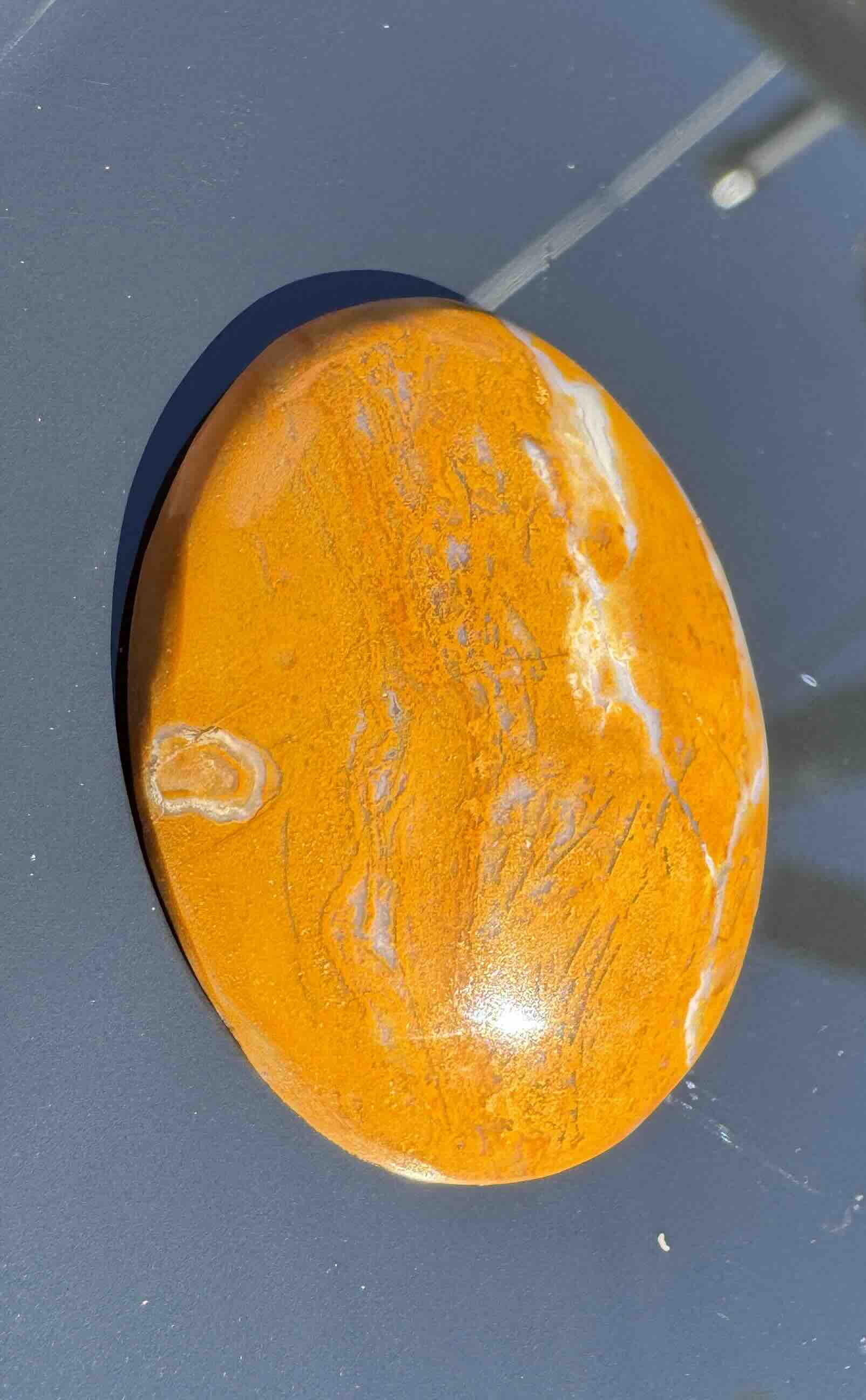 Polished yellow jasper cabochon with unique natural patterns and agate inclusions for jewelry making.